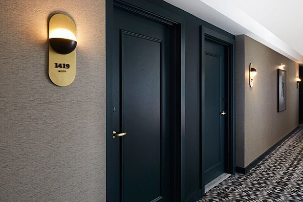 Moderna, mörkblå hotellrumsdörrar i en tyst korridor.